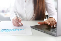 Τα θηλυκά όπλα γράφουν με την ασημένιους μάνδρα και τον τύπο στο lap-top στοκ φωτογραφία Τα θηλυκά όπλα γράφουν με την ασημένιους μάνδρα και τον τύπο στο lap-top στοκ φωτογραφία
