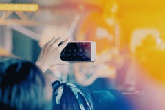 Τα κορίτσια χρησιμοποιούν smartphones για να πάρουν τις εικόνες στις συναυλίες στοκ εικόνα με δικαίωμα ελεύθερης χρήσης Τα κορίτσια χρησιμοποιούν smartphones για να πάρουν τις εικόνες στις συναυλίες στοκ εικόνα με δικαίωμα ελεύθερης χρήσης