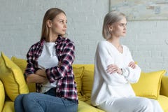 Τα λεσβιακά θηλυκά συνδέουν στο κάθισμα περιστασιακών ενδυμάτων πλάτη με πλάτη με τα χέρια στον κίτρινο καναπέ μετά από τη φιλονι στοκ εικόνες Τα λεσβιακά θηλυκά συνδέουν στο κάθισμα περιστασιακών ενδυμάτων πλάτη με πλάτη με τα χέρια στον κίτρινο καναπέ μετά από τη φιλονι στοκ εικόνες