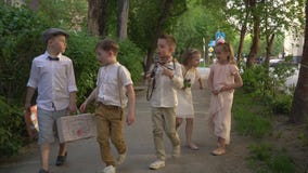 Τα παιδιά με την κάρτα περπατούν γύρω από την πόλη Κορίτσια στα όμορφα ελαφριά φορέματα απόθεμα βίντεο Τα παιδιά με την κάρτα περπατούν γύρω από την πόλη Κορίτσια στα όμορφα ελαφριά φορέματα απόθεμα βίντεο