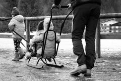Τα παιδιά παίζουν με ένα έλκηθρο στο πάρκο το χειμώνα στοκ εικόνες με δικαίωμα ελεύθερης χρήσης Τα παιδιά παίζουν με ένα έλκηθρο στο πάρκο το χειμώνα στοκ εικόνες με δικαίωμα ελεύθερης χρήσης