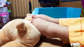 Τα πόδια μωρών με την κούκλα κλείνουν επάνω τη φωτογραφία στοκ φωτογραφίες με δικαίωμα ελεύθερης χρήσης Τα πόδια μωρών με την κούκλα κλείνουν επάνω τη φωτογραφία στοκ φωτογραφίες με δικαίωμα ελεύθερης χρήσης