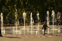 Τα τρεξίματα παιδιών μακρυά από το ρεύμα του νερού στην πηγή στοκ εικόνα Τα τρεξίματα παιδιών μακρυά από το ρεύμα του νερού στην πηγή στοκ εικόνα