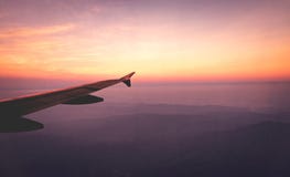 Τα φτερά αεροπλάνων στον ουρανό και βουνά βλέπουν τη σκηνή στην ανατολή Ταξίδι και περιπέτεια στοκ φωτογραφία με δικαίωμα ελεύθερης χρήσης Τα φτερά αεροπλάνων στον ουρανό και βουνά βλέπουν τη σκηνή στην ανατολή Ταξίδι και περιπέτεια στοκ φωτογραφία με δικαίωμα ελεύθερης χρήσης