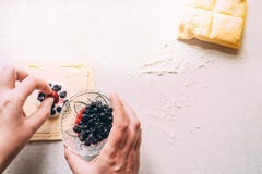 Τα χέρια της γυναίκας προετοιμάζουν ένα κέικ με την τοποθέτηση των μούρων στη ζύμη Σε ένα λευκό ο πίνακας βρίσκεται μια ζύμη πρωί στοκ φωτογραφία με δικαίωμα ελεύθερης χρήσης Τα χέρια της γυναίκας προετοιμάζουν ένα κέικ με την τοποθέτηση των μούρων στη ζύμη Σε ένα λευκό ο πίνακας βρίσκεται μια ζύμη πρωί στοκ φωτογραφία με δικαίωμα ελεύθερης χρήσης