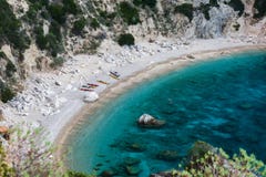 Τα χρωματισμένα καγιάκ στέκονται στην αμμώδη ακτή σε έναν κόλπο με το κυανό νερό στοκ φωτογραφίες με δικαίωμα ελεύθερης χρήσης Τα χρωματισμένα καγιάκ στέκονται στην αμμώδη ακτή σε έναν κόλπο με το κυανό νερό στοκ φωτογραφίες με δικαίωμα ελεύθερης χρήσης