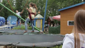 Τηλεοπτική χρήση βλαστών Mom ένα smartphone ως παιδιά που πηδούν στο τραμπολίνο απόθεμα βίντεο Τηλεοπτική χρήση βλαστών Mom ένα smartphone ως παιδιά που πηδούν στο τραμπολίνο απόθεμα βίντεο