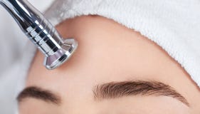 Το cosmetologist κάνει τη διαδικασία Microdermabrasion του του προσώπου δέρματος μιας όμορφης, νέας γυναίκας στοκ φωτογραφίες Το cosmetologist κάνει τη διαδικασία Microdermabrasion του του προσώπου δέρματος μιας όμορφης, νέας γυναίκας στοκ φωτογραφίες