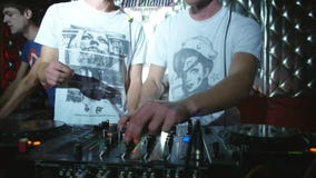 Το DJs ελέγχει τα faders και τα εξογκώματα κίνησης γραφείων μίξης στη λέσχη disco λαμβάνοντας υπόψη τις φλόγες απόθεμα βίντεο Το DJs ελέγχει τα faders και τα εξογκώματα κίνησης γραφείων μίξης στη λέσχη disco λαμβάνοντας υπόψη τις φλόγες απόθεμα βίντεο