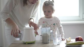Το Mom και λίγη κόρη προετοιμάζουν ένα milkshake απόθεμα βίντεο Το Mom και λίγη κόρη προετοιμάζουν ένα milkshake απόθεμα βίντεο