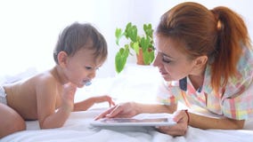Το Mom και ο γιος εξετάζουν το smartphone στο κρεβάτι απόθεμα βίντεο Το Mom και ο γιος εξετάζουν το smartphone στο κρεβάτι απόθεμα βίντεο