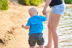 Το Mom και ο γιος της περπατούν κατά μήκος της όχθης ποταμού μια καυτή θερινή ημέρα στοκ εικόνες Το Mom και ο γιος της περπατούν κατά μήκος της όχθης ποταμού μια καυτή θερινή ημέρα στοκ εικόνες