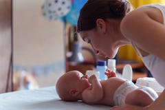 Το Mom με το χαριτωμένο χαμόγελο φροντίζει το νεογέννητο αγόρι της στο μεταβαλλόμενο πίνακα μωρών Στοκ φωτογραφία με δικαίωμα ελεύθερης χρήσης Το Mom με το χαριτωμένο χαμόγελο φροντίζει το νεογέννητο αγόρι της στο μεταβαλλόμενο πίνακα μωρών Στοκ φωτογραφία με δικαίωμα ελεύθερης χρήσης