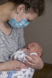 Το Mom, που είναι άρρωστο, κρατά το μωρό της σε μια προστατευτική ιατρική μάσκα στοκ φωτογραφίες με δικαίωμα ελεύθερης χρήσης Το Mom, που είναι άρρωστο, κρατά το μωρό της σε μια προστατευτική ιατρική μάσκα στοκ φωτογραφίες με δικαίωμα ελεύθερης χρήσης
