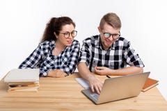 Το Nerds, geek, και αστεία έννοια ανθρώπων - αστείο ζεύγος σπουδαστών στα γυαλιά που κάθεται στον πίνακα στοκ φωτογραφίες με δικαίωμα ελεύθερης χρήσης Το Nerds, geek, και αστεία έννοια ανθρώπων - αστείο ζεύγος σπουδαστών στα γυαλιά που κάθεται στον πίνακα στοκ φωτογραφίες με δικαίωμα ελεύθερης χρήσης