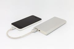 Το Smartphone φορτίζει από μια εξωτερική μπαταρία στοκ εικόνα Το Smartphone φορτίζει από μια εξωτερική μπαταρία στοκ εικόνα