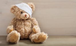 Το Teddy αφορά με τον επίδεσμο ένα ξύλινο πάτωμα στοκ εικόνα με δικαίωμα ελεύθερης χρήσης Το Teddy αφορά με τον επίδεσμο ένα ξύλινο πάτωμα στοκ εικόνα με δικαίωμα ελεύθερης χρήσης