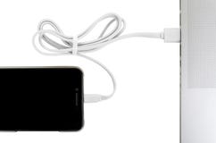 Το άσπρο καλώδιο usb κινηματογραφήσεων σε πρώτο πλάνο συνδέει το τηλέφωνο και το φορητό προσωπικό υπολογιστή έννοια νέας τεχνολογ Στοκ Εικόνες Το άσπρο καλώδιο usb κινηματογραφήσεων σε πρώτο πλάνο συνδέει το τηλέφωνο και το φορητό προσωπικό υπολογιστή έννοια νέας τεχνολογ Στοκ Εικόνες