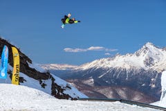 Το άτομο snowboarder πετά την ελεύθερη κολύμβηση από ένα άλμα στην αιχμή βουνών Chugush και το υπόβαθρο μπλε ουρανού στο χειμώνα στοκ φωτογραφία με δικαίωμα ελεύθερης χρήσης Το άτομο snowboarder πετά την ελεύθερη κολύμβηση από ένα άλμα στην αιχμή βουνών Chugush και το υπόβαθρο μπλε ουρανού στο χειμώνα στοκ φωτογραφία με δικαίωμα ελεύθερης χρήσης