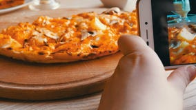 Το αγόρι εφήβων παίρνει μια φωτογραφία των τροφίμων σε ένα smartphone Ιταλική πίτσα στον πίνακα εστιατορίων απόθεμα βίντεο Το αγόρι εφήβων παίρνει μια φωτογραφία των τροφίμων σε ένα smartphone Ιταλική πίτσα στον πίνακα εστιατορίων απόθεμα βίντεο