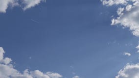 Το αεροπλάνο πετά ενάντια σε έναν μπλε ουρανό με τα άσπρα σύννεφα φιλμ μικρού μήκους Το αεροπλάνο πετά ενάντια σε έναν μπλε ουρανό με τα άσπρα σύννεφα φιλμ μικρού μήκους