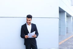 Το αραβικό όμορφο χαμόγελο σπουδαστών, κρατά και εξετάζει τα έγγραφα ν στοκ εικόνες Το αραβικό όμορφο χαμόγελο σπουδαστών, κρατά και εξετάζει τα έγγραφα ν στοκ εικόνες