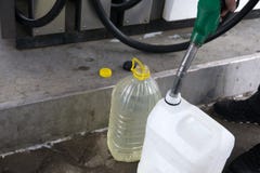 Το ενήλικο άτομο γεμίζει ένα αυτοκίνητο με τη βενζίνη σε έναν σταθμό καυσίμων το χειμώνα ανεφοδιάζοντας σε καύσιμα εκμετάλλευση α στοκ φωτογραφία με δικαίωμα ελεύθερης χρήσης Το ενήλικο άτομο γεμίζει ένα αυτοκίνητο με τη βενζίνη σε έναν σταθμό καυσίμων το χειμώνα ανεφοδιάζοντας σε καύσιμα εκμετάλλευση α στοκ φωτογραφία με δικαίωμα ελεύθερης χρήσης