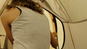 Το ευτυχές κορίτσι τουριστών ξυπνά σε έναν υπνόσακο, ανοίγει την κλειδαριά και κοιτάζει από τη σκηνή στα πλαίσια ενός υψηλού απόθεμα βίντεο Το ευτυχές κορίτσι τουριστών ξυπνά σε έναν υπνόσακο, ανοίγει την κλειδαριά και κοιτάζει από τη σκηνή στα πλαίσια ενός υψηλού απόθεμα βίντεο