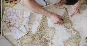 Το ζεύγος προγραμματίζει τις διακοπές χρησιμοποιώντας έναν παγκόσμιο χάρτη Υπόδειξη στις θέσεις χαρτών που επισκέπτονται στο νότο απόθεμα βίντεο Το ζεύγος προγραμματίζει τις διακοπές χρησιμοποιώντας έναν παγκόσμιο χάρτη Υπόδειξη στις θέσεις χαρτών που επισκέπτονται στο νότο απόθεμα βίντεο