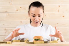 Το κορίτσι θέλει burger Το κορίτσι είναι σε μια διατροφή η γυναίκα θέλει να φάει burger στοκ εικόνες Το κορίτσι θέλει burger Το κορίτσι είναι σε μια διατροφή η γυναίκα θέλει να φάει burger στοκ εικόνες