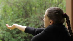 Το κορίτσι κολλά το χέρι της κάτω από τη βροχή, που προσπαθεί να συλλέξει τις μειωμένες σταγόνες βροχής απόθεμα βίντεο Το κορίτσι κολλά το χέρι της κάτω από τη βροχή, που προσπαθεί να συλλέξει τις μειωμένες σταγόνες βροχής απόθεμα βίντεο