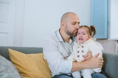 Το κορίτσι μικρών παιδιών φωνάζει στα όπλα του πατέρα της στοκ φωτογραφία με δικαίωμα ελεύθερης χρήσης Το κορίτσι μικρών παιδιών φωνάζει στα όπλα του πατέρα της στοκ φωτογραφία με δικαίωμα ελεύθερης χρήσης