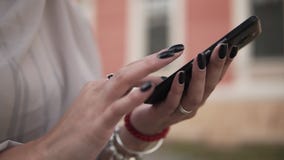 Το κορίτσι που δείχνει το δάχτυλο στο smartphone οθόνης στο υπόβαθρο είναι θολωμένη παλαιά άποψη πόλεων, γυναίκα με το μαύρο μανι απόθεμα βίντεο Το κορίτσι που δείχνει το δάχτυλο στο smartphone οθόνης στο υπόβαθρο είναι θολωμένη παλαιά άποψη πόλεων, γυναίκα με το μαύρο μανι απόθεμα βίντεο