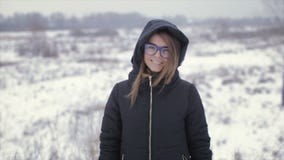 Το κορίτσι σε ένα μαύρο σακάκι σε ένα υπόβαθρο ενός χειμερινού τομέα φιλμ μικρού μήκους Το κορίτσι σε ένα μαύρο σακάκι σε ένα υπόβαθρο ενός χειμερινού τομέα φιλμ μικρού μήκους