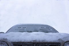 Το λυπημένο και ευτυχές χαμόγελο στο χιονώδη ανεμοφράκτη ενός αυτοκινήτου στοκ φωτογραφία με δικαίωμα ελεύθερης χρήσης Το λυπημένο και ευτυχές χαμόγελο στο χιονώδη ανεμοφράκτη ενός αυτοκινήτου στοκ φωτογραφία με δικαίωμα ελεύθερης χρήσης