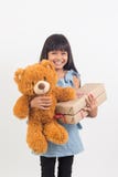 Το μικρό κορίτσι αγκαλιάζει μια teddy αρκούδα με το κιβώτιο δώρων στοκ εικόνες Το μικρό κορίτσι αγκαλιάζει μια teddy αρκούδα με το κιβώτιο δώρων στοκ εικόνες