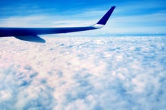 Το μπλε φτερό ενός μεγάλου αεροπλάνου, που πετά κατά τη διάρκεια του άσ στοκ εικόνα με δικαίωμα ελεύθερης χρήσης Το μπλε φτερό ενός μεγάλου αεροπλάνου, που πετά κατά τη διάρκεια του άσ στοκ εικόνα με δικαίωμα ελεύθερης χρήσης