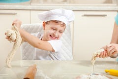 Το μωρό ζυμώνει τη ζύμη στο αλεύρι στοκ φωτογραφίες με δικαίωμα ελεύθερης χρήσης Το μωρό ζυμώνει τη ζύμη στο αλεύρι στοκ φωτογραφίες με δικαίωμα ελεύθερης χρήσης