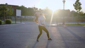Το μόνο λεπτό κορίτσι χορευτών χορεύει σε ένα ναυπηγείο των σπιτιών σε μια πόλη στο χρόνο ηλιοβασιλέματος, που και που εκτελεί το απόθεμα βίντεο Το μόνο λεπτό κορίτσι χορευτών χορεύει σε ένα ναυπηγείο των σπιτιών σε μια πόλη στο χρόνο ηλιοβασιλέματος, που και που εκτελεί το απόθεμα βίντεο