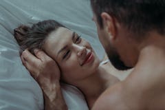 Το νέο αγαπώντας ζεύγος αγκαλιάζει στο κρεβάτι Στοκ φωτογραφία με δικαίωμα ελεύθερης χρήσης Το νέο αγαπώντας ζεύγος αγκαλιάζει στο κρεβάτι Στοκ φωτογραφία με δικαίωμα ελεύθερης χρήσης