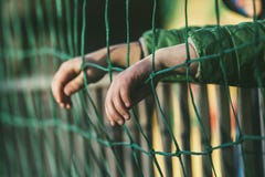 Το νέο αγόρι προσέχει ένα αθλητικό παιχνίδι από τους λευκαντές με ένα ποδόσφαιρο στοκ φωτογραφίες με δικαίωμα ελεύθερης χρήσης Το νέο αγόρι προσέχει ένα αθλητικό παιχνίδι από τους λευκαντές με ένα ποδόσφαιρο στοκ φωτογραφίες με δικαίωμα ελεύθερης χρήσης