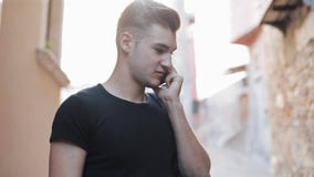 Το νέο ελκυστικό άτομο που περπατά γύρω από την πόλη μιλά στο smartphone απόθεμα βίντεο Το νέο ελκυστικό άτομο που περπατά γύρω από την πόλη μιλά στο smartphone απόθεμα βίντεο