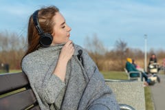 Το νέο, ευτυχές redhead κορίτσι την άνοιξη στο πάρκο κοντά στον ποταμό ακούει τη μουσική μέσω των ασύρματων ακουστικών bluetooth στοκ εικόνες Το νέο, ευτυχές redhead κορίτσι την άνοιξη στο πάρκο κοντά στον ποταμό ακούει τη μουσική μέσω των ασύρματων ακουστικών bluetooth στοκ εικόνες