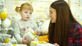 Το ξανθό κορίτσι μικρών παιδιών με τη μητέρα brunette ανοίγει τα κιβώτια δώρων Χριστουγέννων στο σπίτι απόθεμα βίντεο Το ξανθό κορίτσι μικρών παιδιών με τη μητέρα brunette ανοίγει τα κιβώτια δώρων Χριστουγέννων στο σπίτι απόθεμα βίντεο