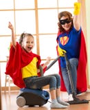 Το παιδί και η μητέρα έντυσαν ως superheroes χρησιμοποίηση της ηλεκτρικής σκούπας στο δωμάτιο Οικογένεια - η γυναίκα και η κόρη π στοκ εικόνες Το παιδί και η μητέρα έντυσαν ως superheroes χρησιμοποίηση της ηλεκτρικής σκούπας στο δωμάτιο Οικογένεια - η γυναίκα και η κόρη π στοκ εικόνες