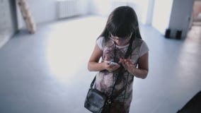 Το παιδί κοριτσιών χρησιμοποιεί το τηλέφωνό τους στο στούντιο απόθεμα βίντεο Το παιδί κοριτσιών χρησιμοποιεί το τηλέφωνό τους στο στούντιο απόθεμα βίντεο
