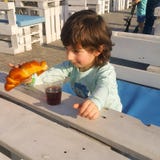 Το παιδί εξετάζει το σάντουιτς, και το σάντουιτς στο παιδί στοκ εικόνες Το παιδί εξετάζει το σάντουιτς, και το σάντουιτς στο παιδί στοκ εικόνες