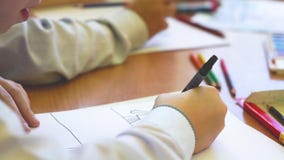 Το παιδί κάθεται σε έναν πίνακα και επισύρει την προσοχή σε χαρτί απόθεμα βίντεο Το παιδί κάθεται σε έναν πίνακα και επισύρει την προσοχή σε χαρτί απόθεμα βίντεο
