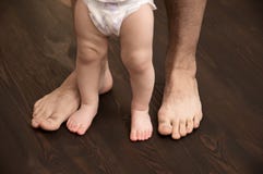 Το παιδί κάνει το πρώτο βήμα Μεγάλα αρσενικά πόδια με τα μικρά πόδια μωρών Ο μπαμπάς βοηθά το παιδί να λάβει τα πρώτα μέτρα στοκ εικόνες με δικαίωμα ελεύθερης χρήσης Το παιδί κάνει το πρώτο βήμα Μεγάλα αρσενικά πόδια με τα μικρά πόδια μωρών Ο μπαμπάς βοηθά το παιδί να λάβει τα πρώτα μέτρα στοκ εικόνες με δικαίωμα ελεύθερης χρήσης