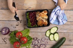 Το παιδί κρατά το εμπορευματοκιβώτιο τροφίμων με τα ψημένα στη σχάρα φτερά κοτόπουλου, μπλε πετσέτα στοκ εικόνα με δικαίωμα ελεύθερης χρήσης Το παιδί κρατά το εμπορευματοκιβώτιο τροφίμων με τα ψημένα στη σχάρα φτερά κοτόπουλου, μπλε πετσέτα στοκ εικόνα με δικαίωμα ελεύθερης χρήσης